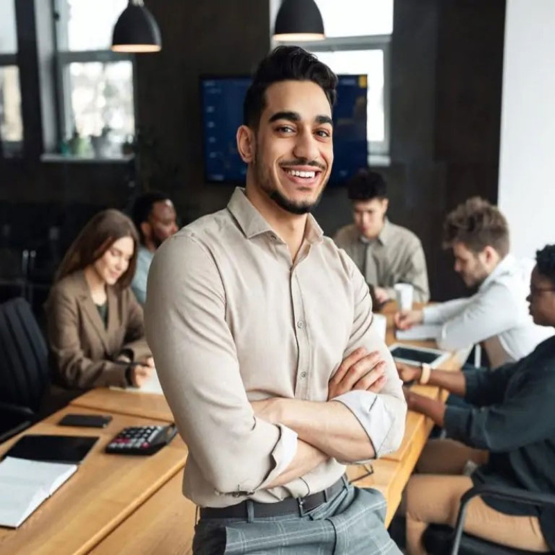Business man smiling as colleagues work, help to grow management